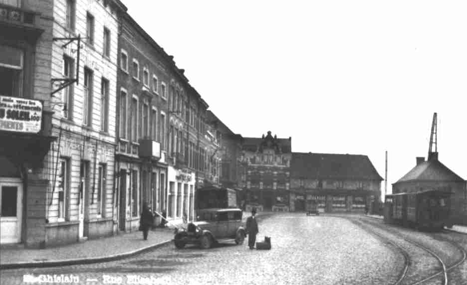 Saint-Ghislain : rue de la Station. Le tram à vapeur se trouve au départ de la ligne Stambruges et de Lens. A l'arrière-plan, l' hôtel Le Pigeon d'or et la Maison des huits heures.