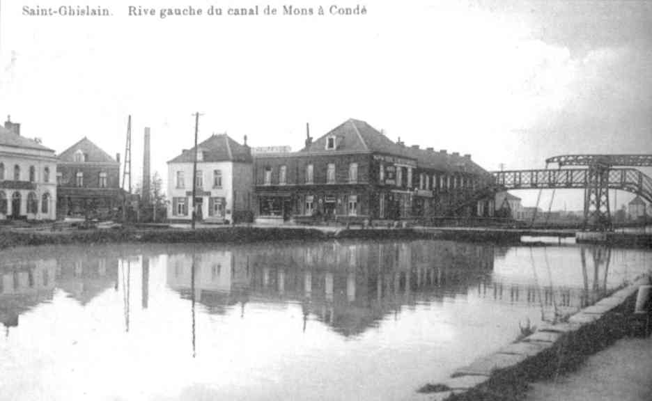 Saint-Ghislain : La rue du Port vonduisait aux rives du canal Mons-Condé que l'on franchissait grâce à un pont-levis ou sur une passerelle pour piétons. L'imposant bâiment est celui des DE Meyer qui fournissaient le matériel de batellerie.