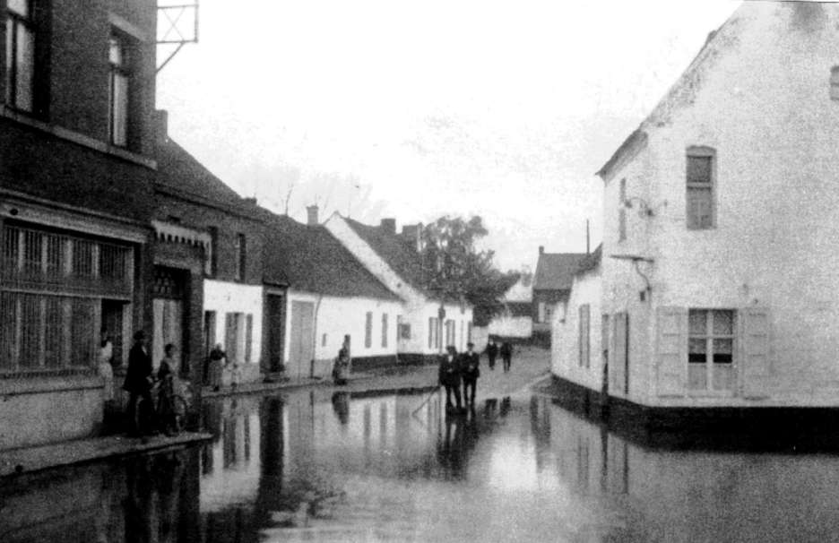 Hautage : rue de la Couronne en 1920 innondée par le ruisseau des Trois Fontaines qui travaisait la place d' Hautrage à ciel ouvert.